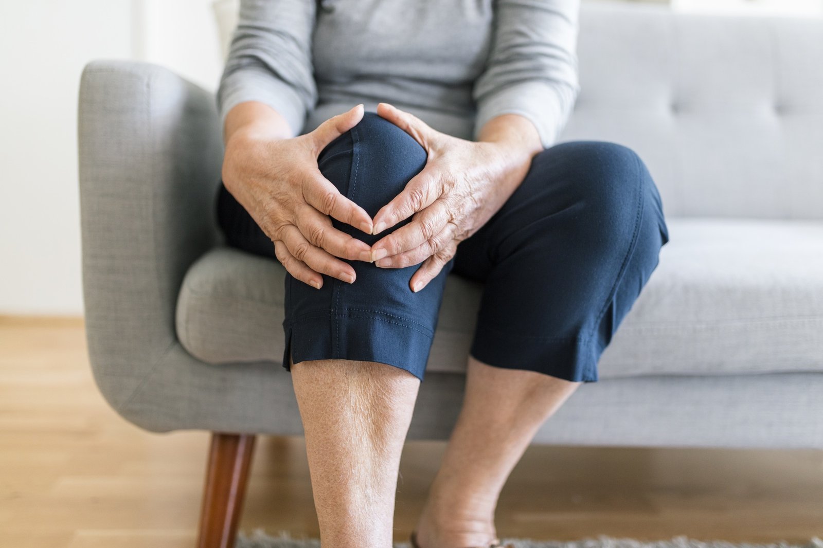 Senior woman holding her painful knee